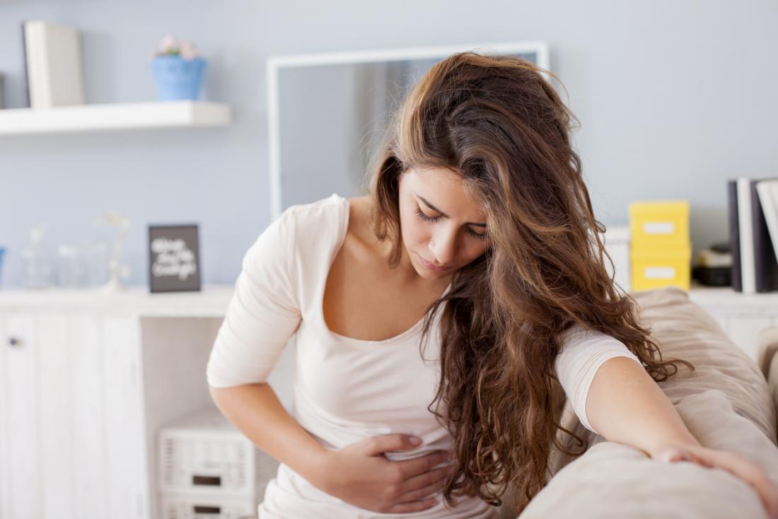 woman holding her stomach in pain