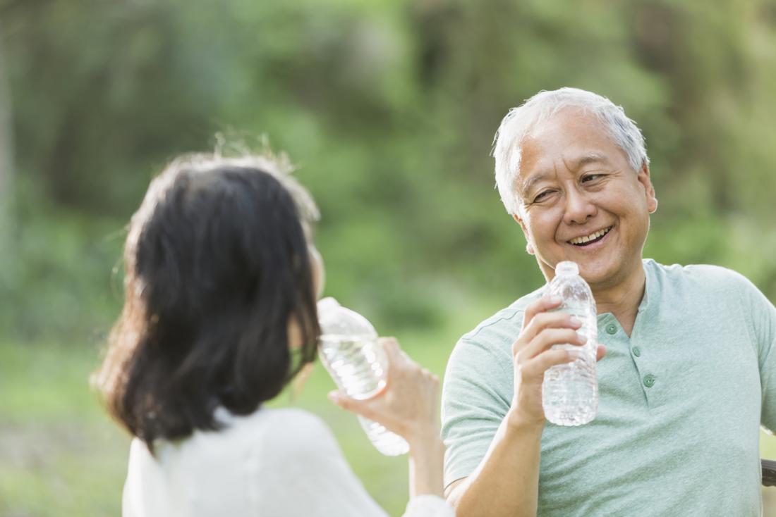 Older Asian adult drinking water