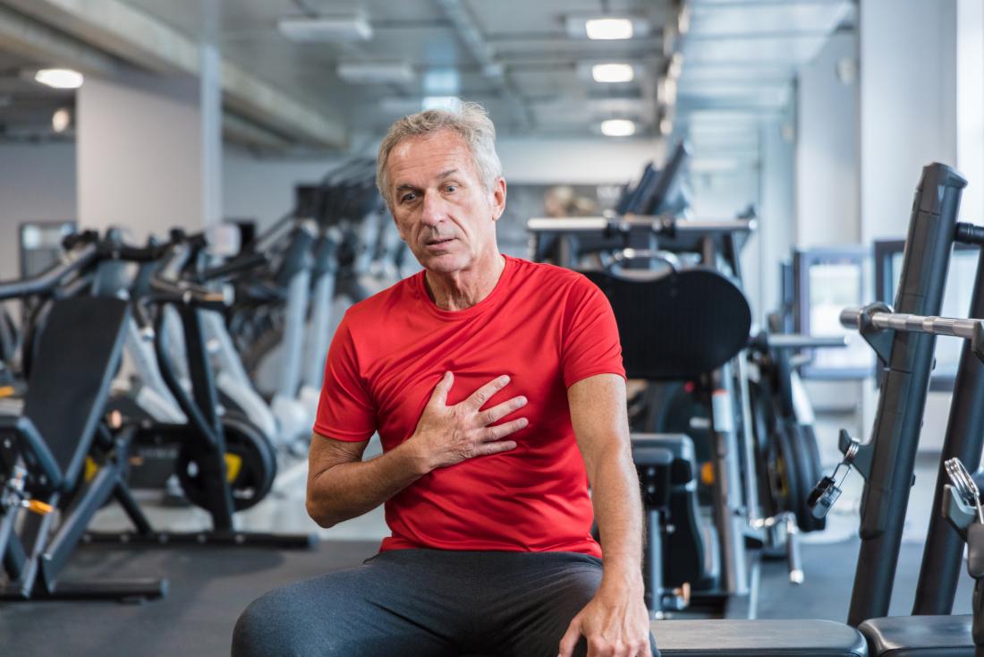 Man in gym holding chest in pain because of heart failure.