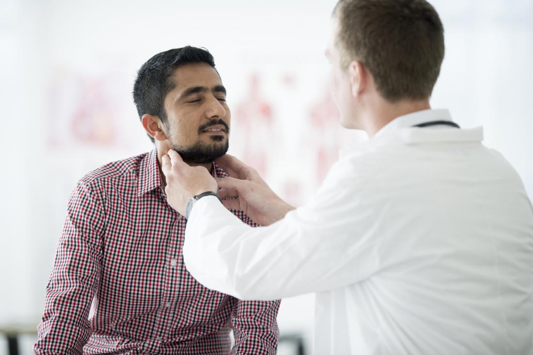 Doctor checking patient for swollen lymph node glands.
