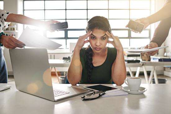 Stressed out woman being bombarded at work