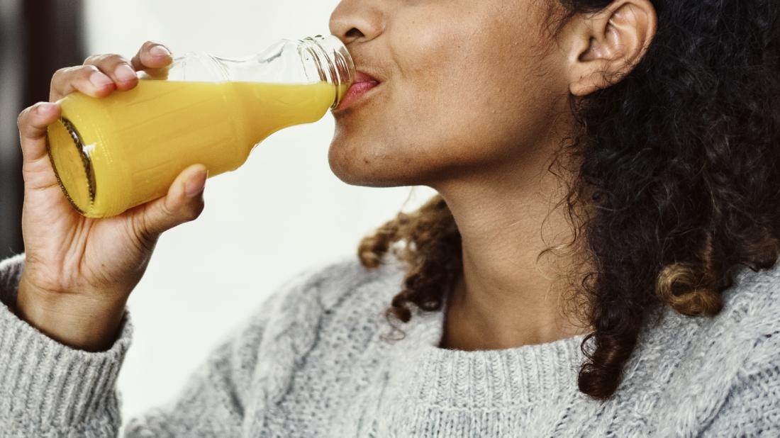 woman drinking orange juice to treat hypoglycemia