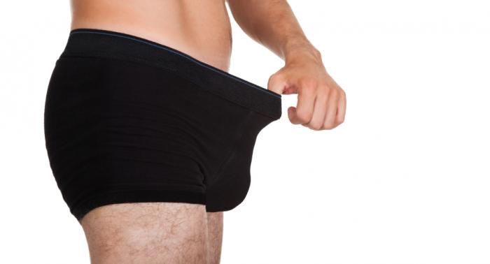 A man inspecting down his pants.