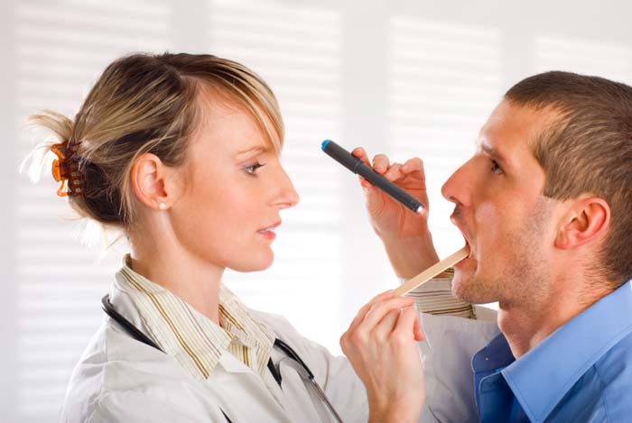 A Doctor checks a patient's throat