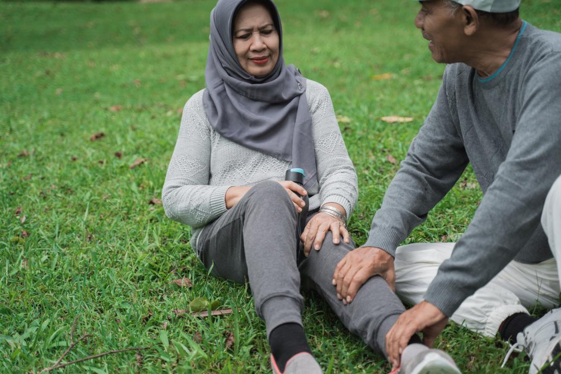 Senior woman with leg pain having massage after running