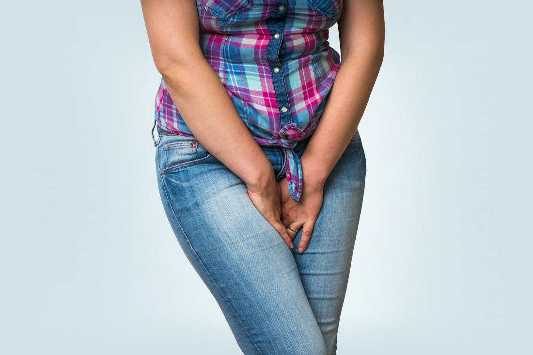 Woman covering her crotch with her hands in pain