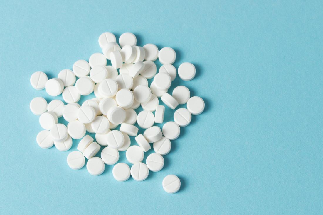 White round pills on blue background