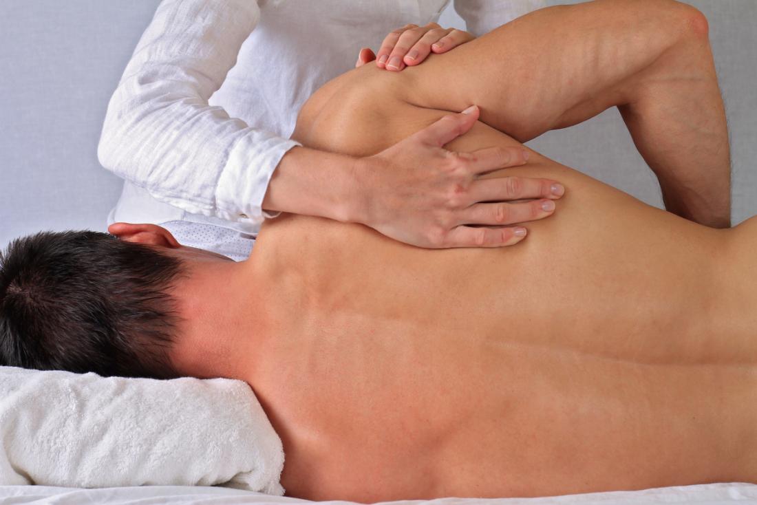 Man undergoing physical therapy on his back.