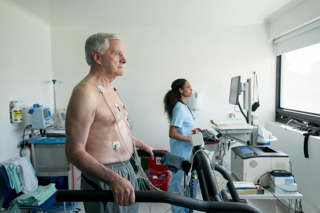 Person performing cardiovascular stress test on treadmill or running machine.