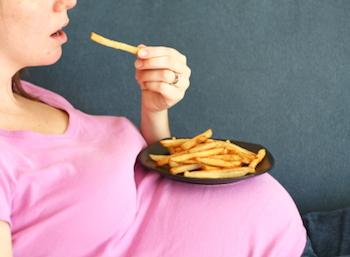 Pregnant lady eating a plate of fries