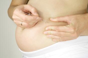 Pregnant lady injecting herself with insulin