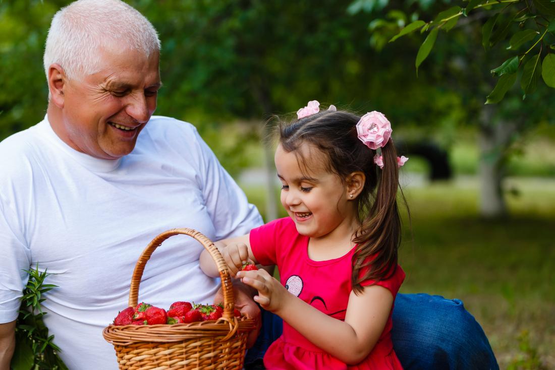 older adult and child with strawberries