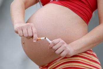 Pregnant lady breaking a cigarette in half