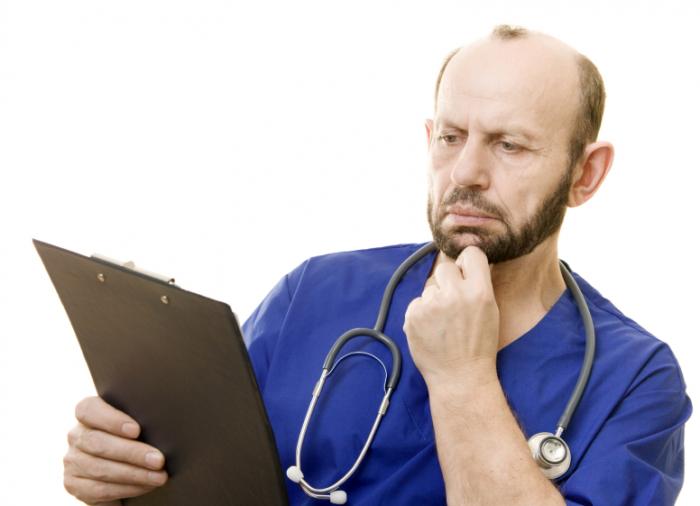Doctor reading notes on a clipboard
