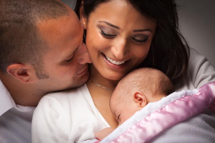 parents holding a baby