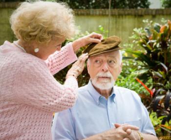 woman putting hat on mans head