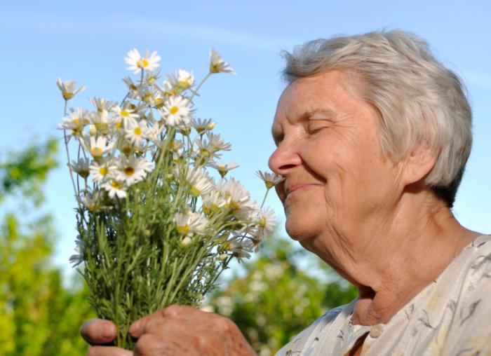 old lady smelling flowers