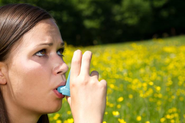 woman using asthma inhaler
