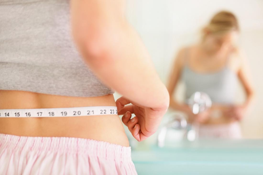 Woman measures waist<!--mce:protected %0A-->