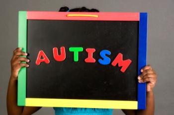 Girl holding up an autism sign.