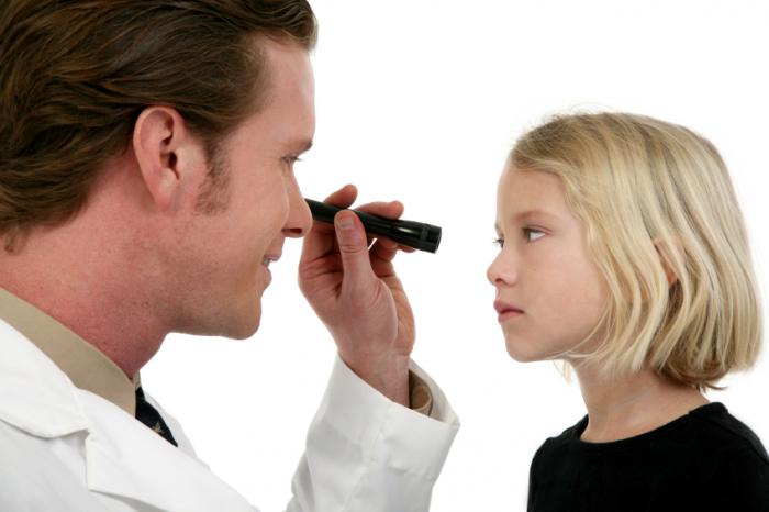 doctor testing young girl's eyes