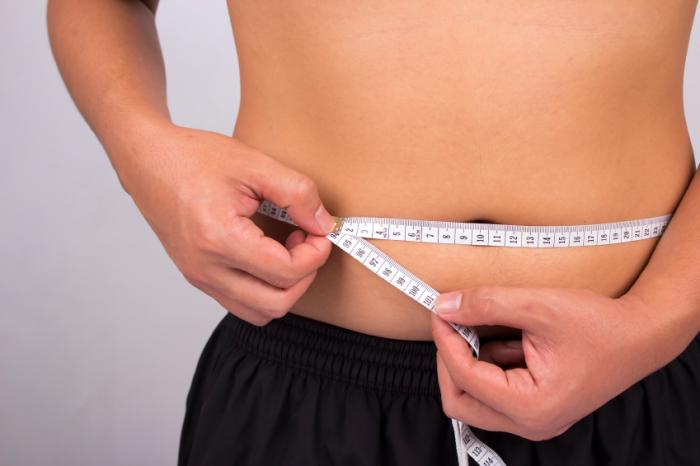 Teen measuring belly.