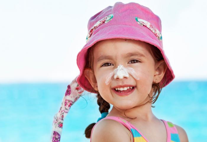 A child wearing sunscreen and a sunhat