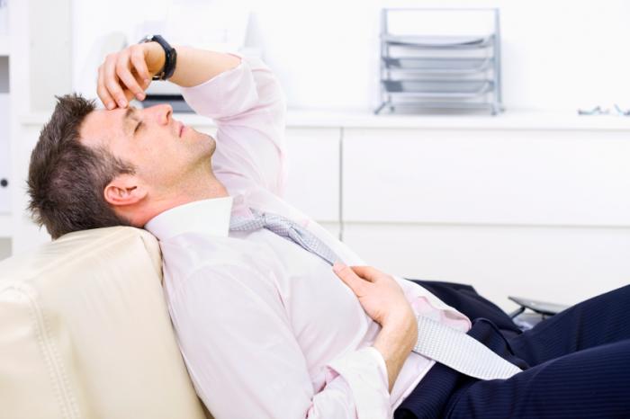 Tired man lying on a sofa.
