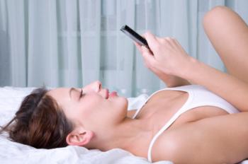 A woman playing Tetris on her phone.