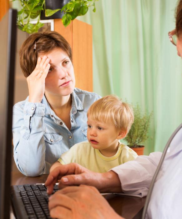 A parent and a young child being seen by a doctor.