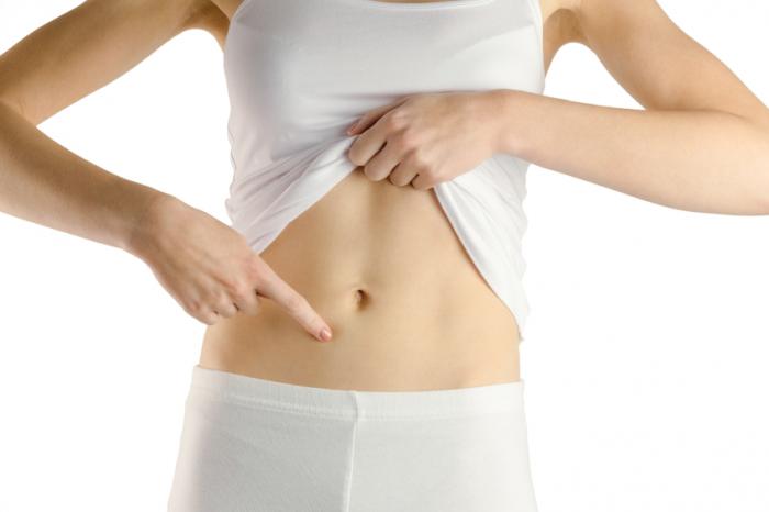 A slim person pointing at their belly.