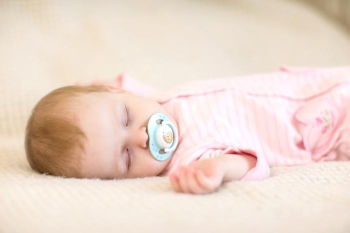 A baby is sleeping on its back.