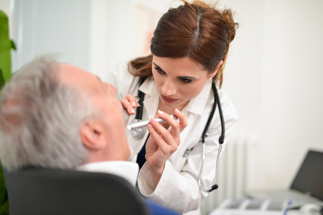 doctor inspecting patients throat