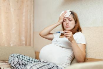 Heavily pregnant woman with thermometer, flu