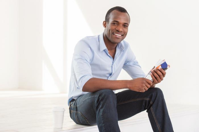 A man is smiling and sitting down.