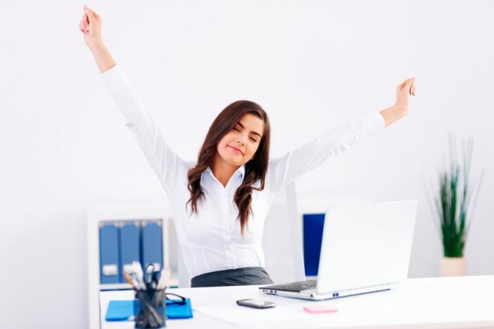 A woman is stretching in an office.