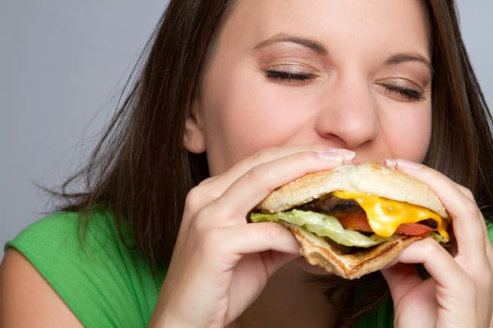 Woman eating cheeseburger