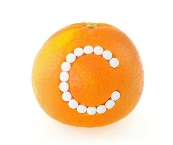 A citrus fruit with a C made of pills.
