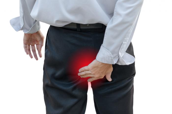 A man with hemorrhoids touches his anus.