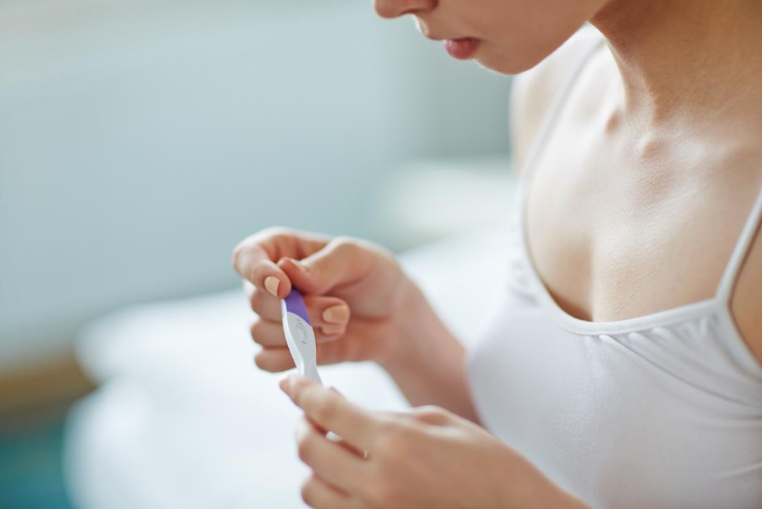 woman holding a pregnancy test