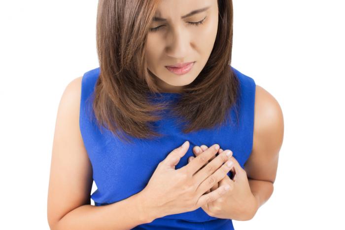 Woman holds chest in pain