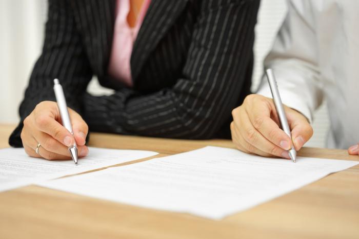 A man and woman sign a form