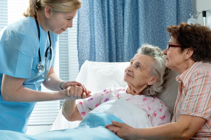 older lady in hospital attended by nurse, relative