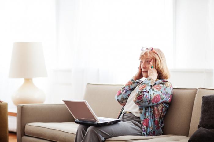 woman using laptop holding head in confusion