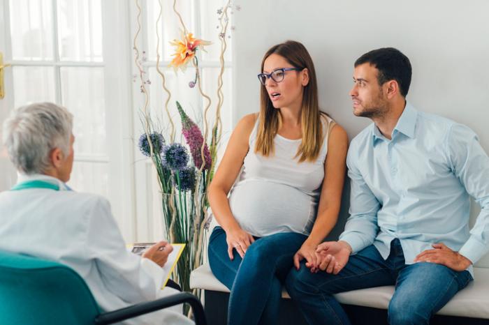 Pregnant lady and partner visit with a doctor