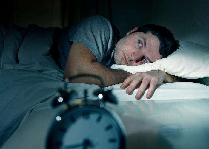 man struggling to sleep insomnia