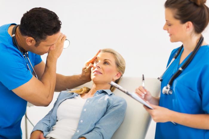 Doctor inspecting a womans eye