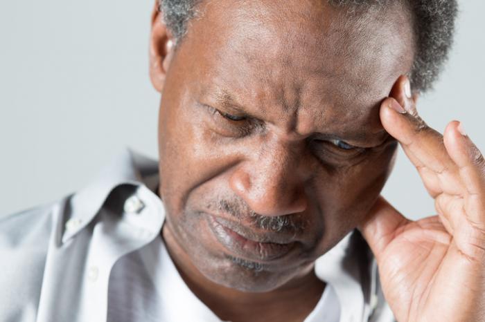 older man holds his head