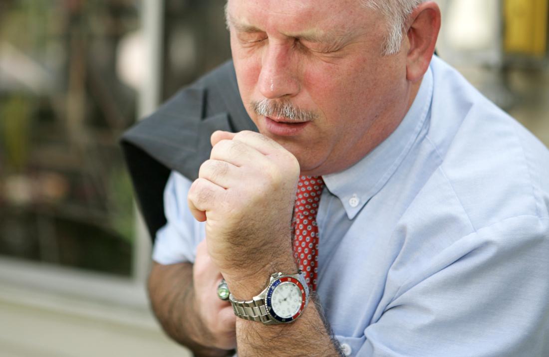 man coughing into hand