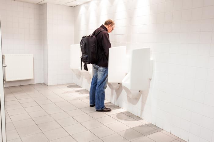 man using urinal